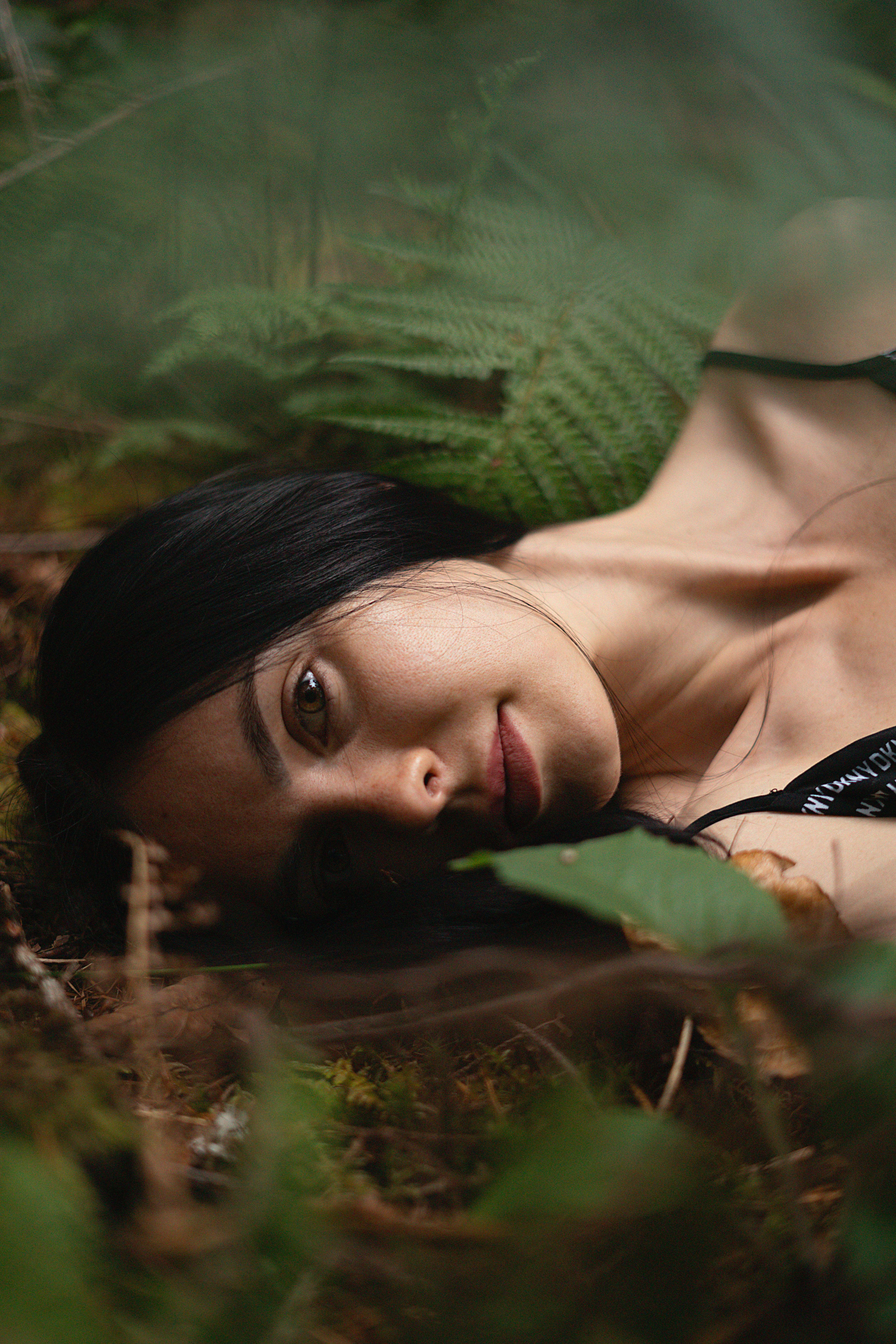 Woman lying among ferns in a forest