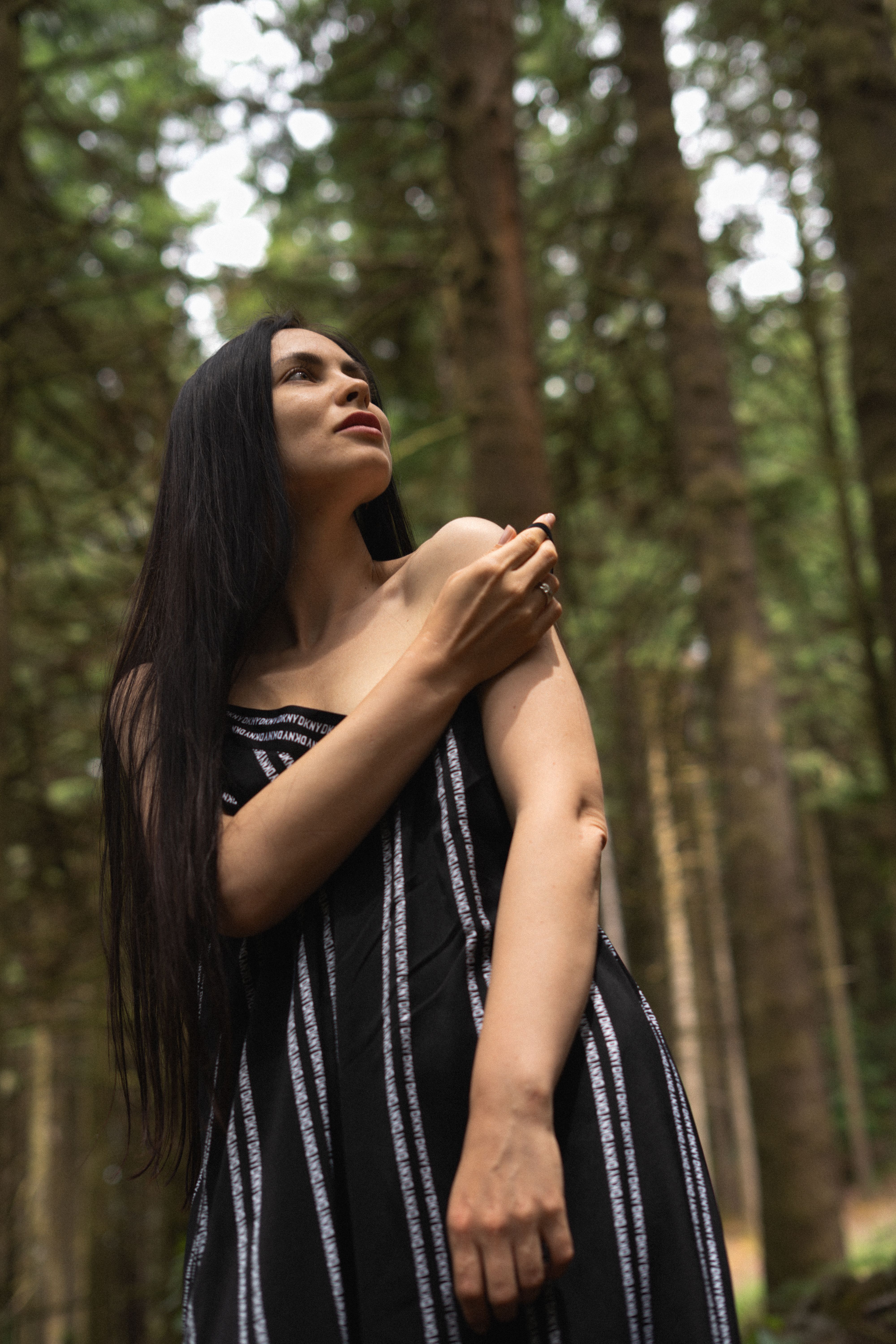 Portrait of a woman in a dark striped dress in the forest