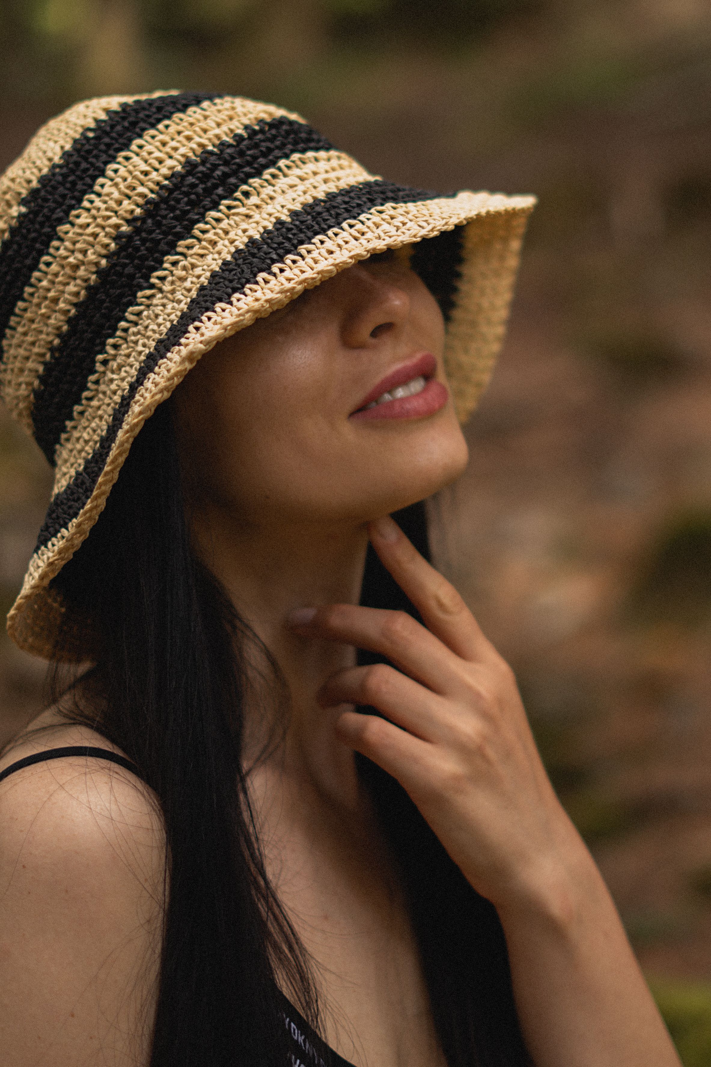 Close-up portrait of a woman in a striped sunhat