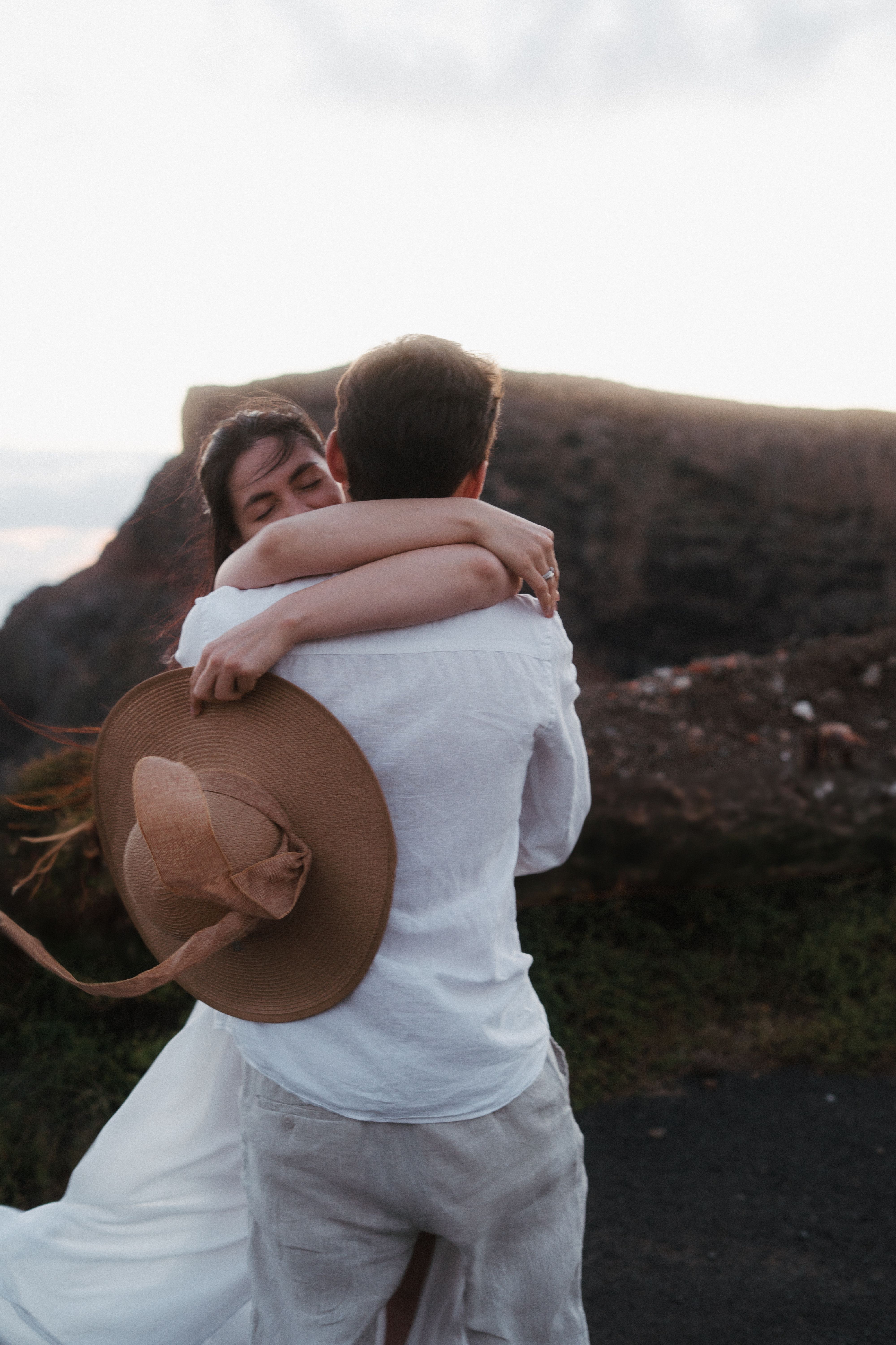 Couple embracing at sunset on a cliff