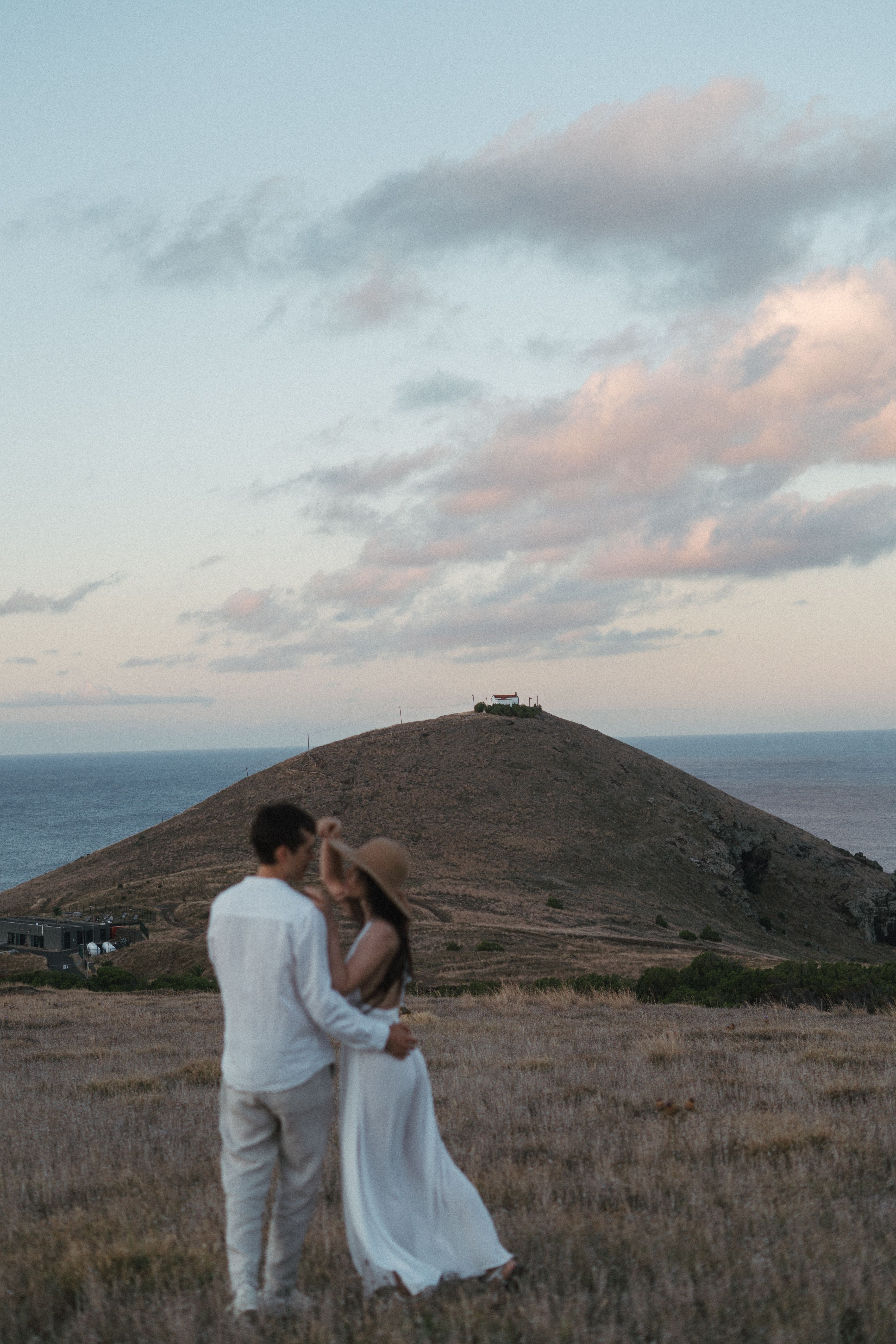 Couple standing together on a coastal hill