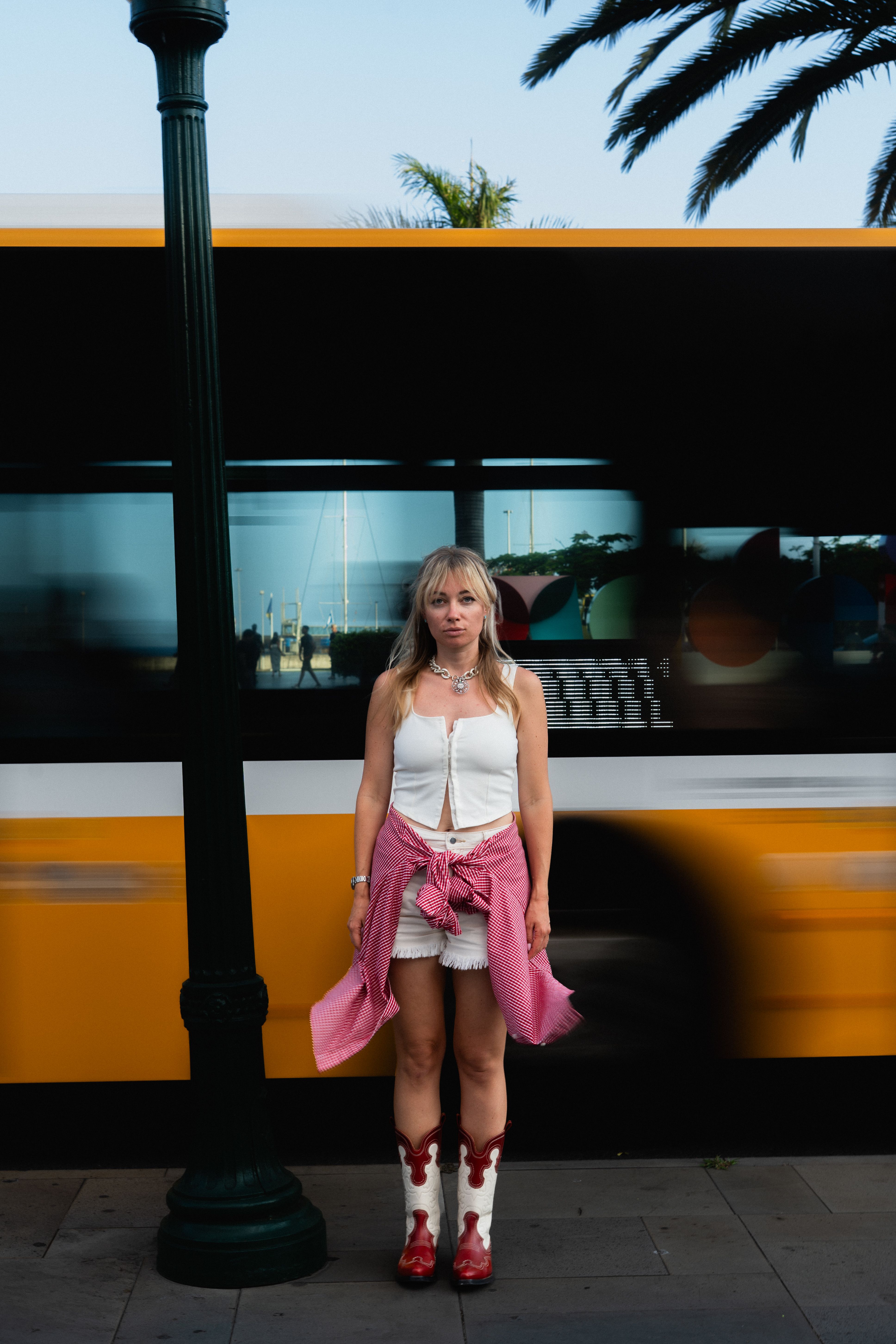 Woman standing in front of a yellow city bus