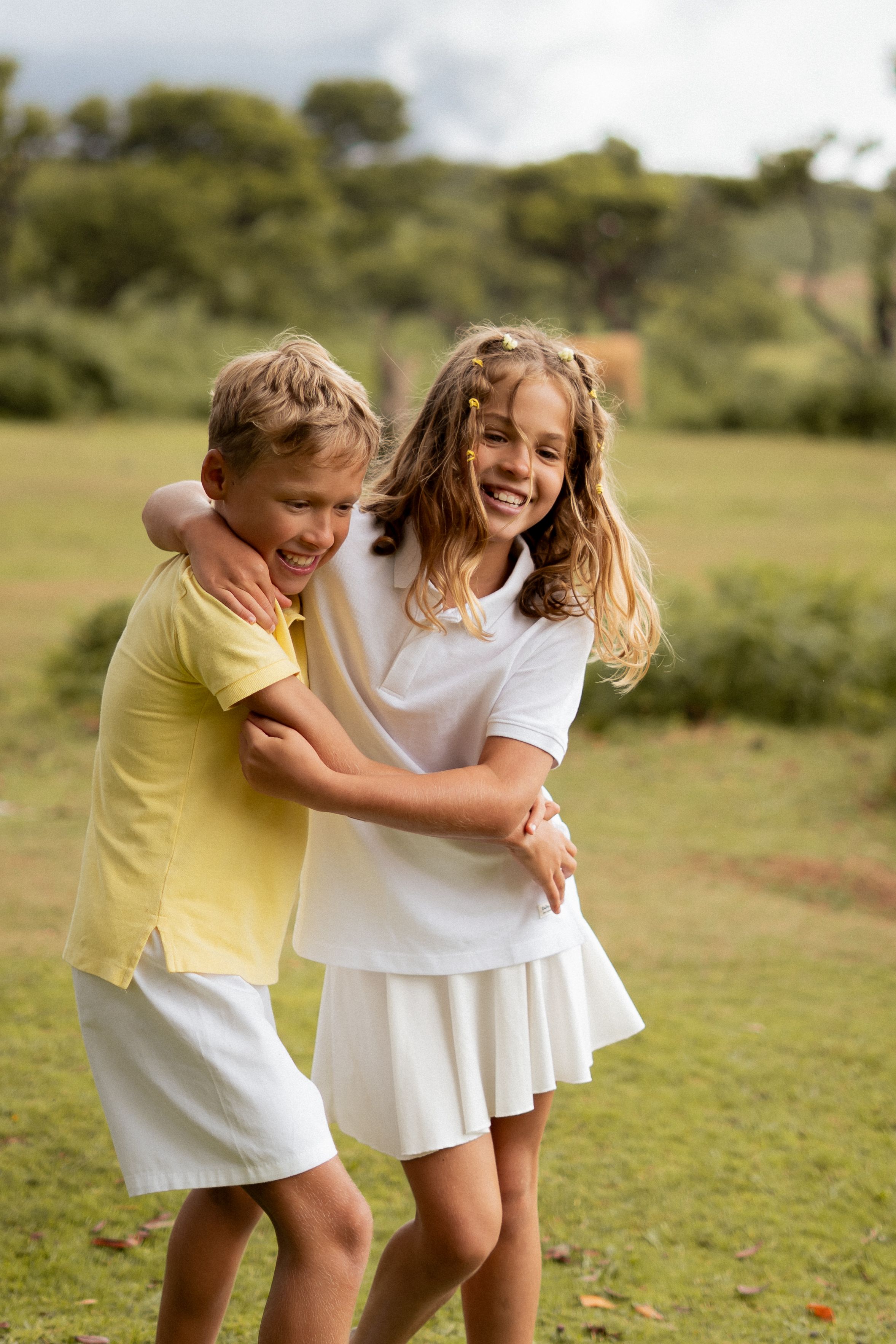 Two children laughing together on a lawn